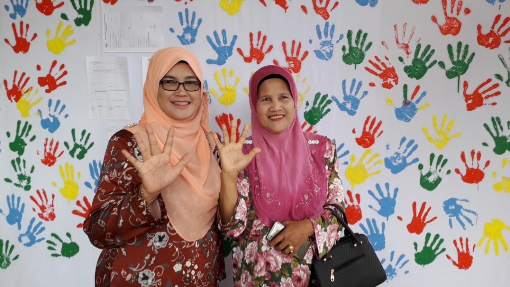 Pn Zalilah (kiri) menunjukkan gaya tangan hentikan keganasan terhadap wanita