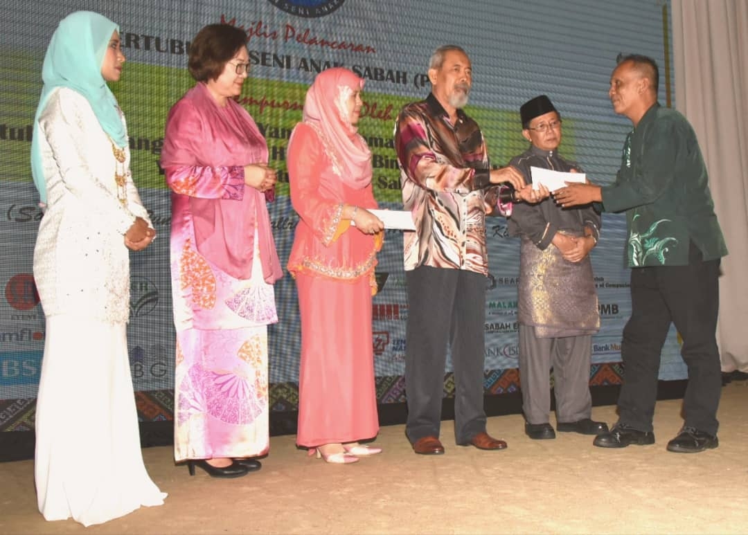 Tun Juhar (tiga dari kanan) menyampaikan sumbangan kepada mantan penari Lembaga Kebudayaan Sabah, Rezuan Din (kiri).