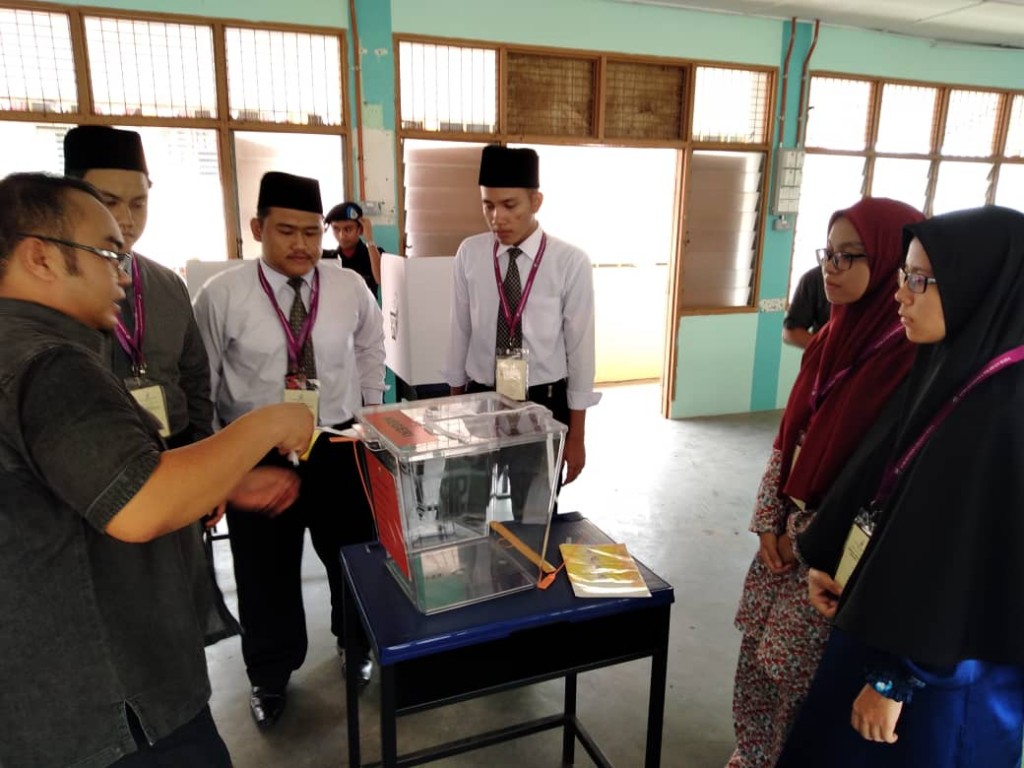 Pegawai SPR, Muhammad Ikhwan Mohd Zain, memberi penerangan kepada pelajar dalam simulasi pilihanraya.