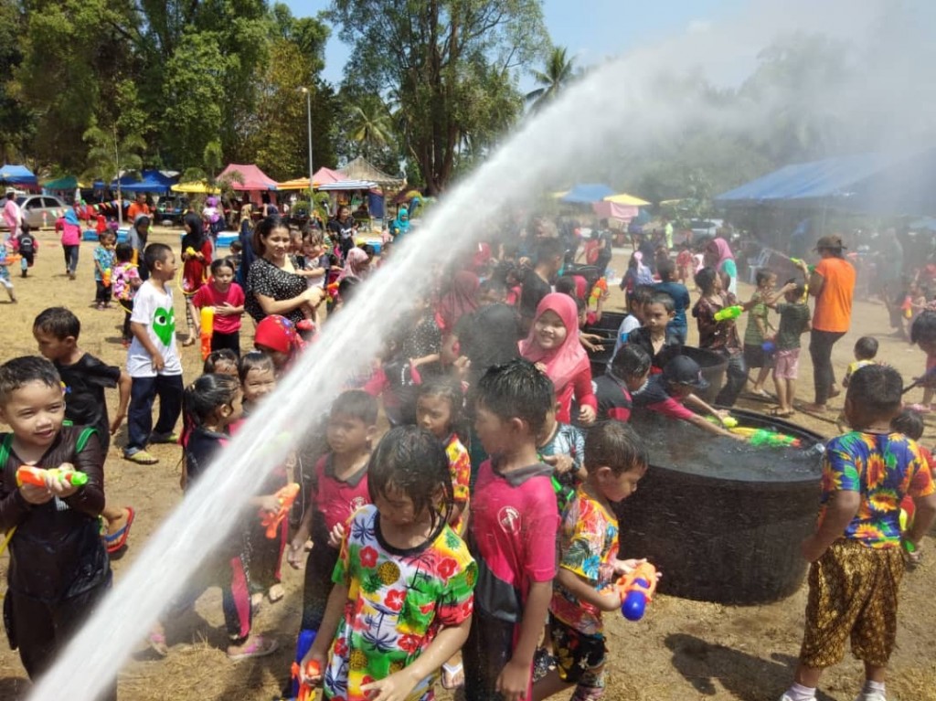 Kanak-kanak disiram air dengan bantuan pihak Jabatan Bomba dan Penyelamat tanda sempurnanya Pesta Songkran