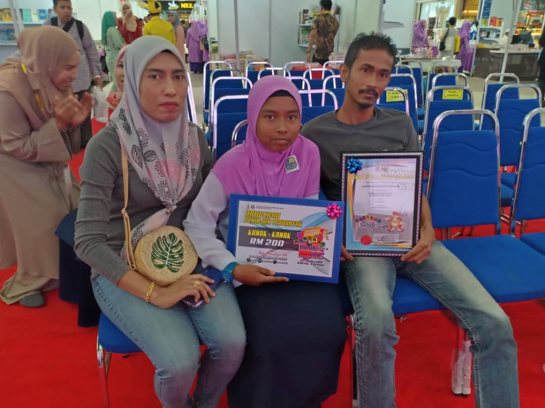 Adik Nur Erlina Sufia bersama ibubapa yang memberi sokongan penuh atas minat membacanya