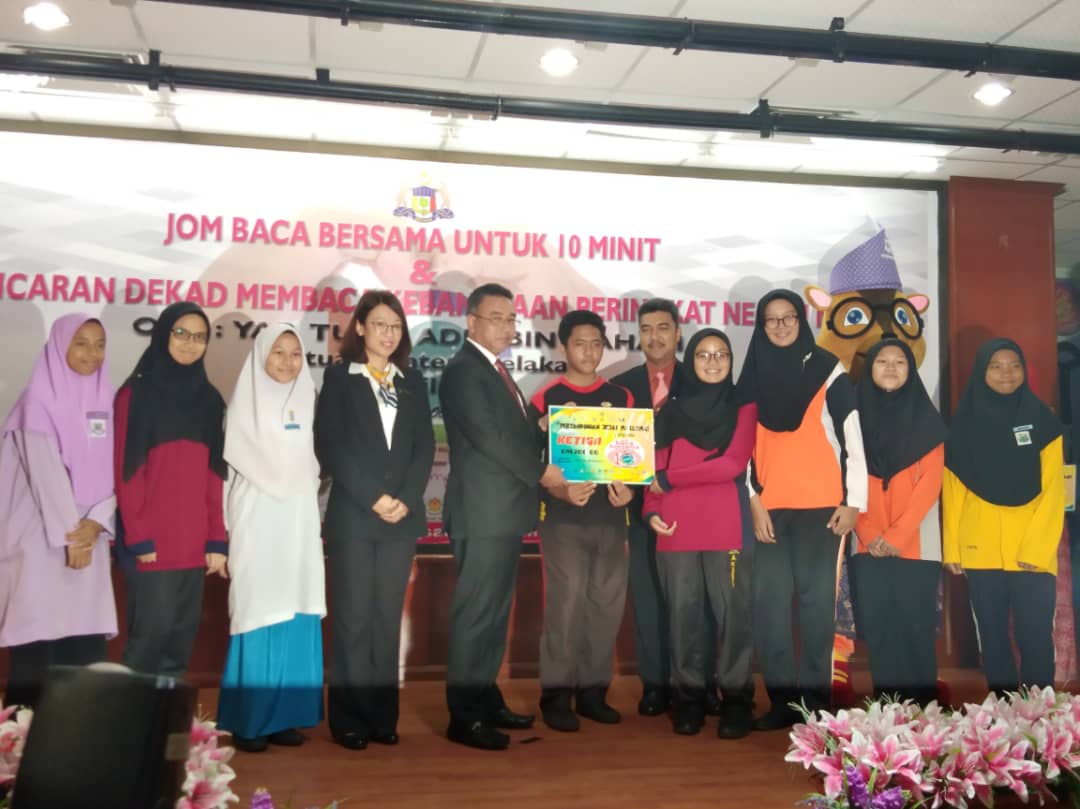 Muhammad Syafiq (tengah) menerima wang tunai RM200 sebagai pemenang tempat ketiga pertandingan jejak maklumat.