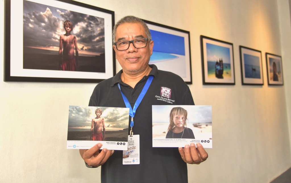 Amri Ginang bersama poskad yang merupakan cenderahati khusus kepada pengunjung galeri.