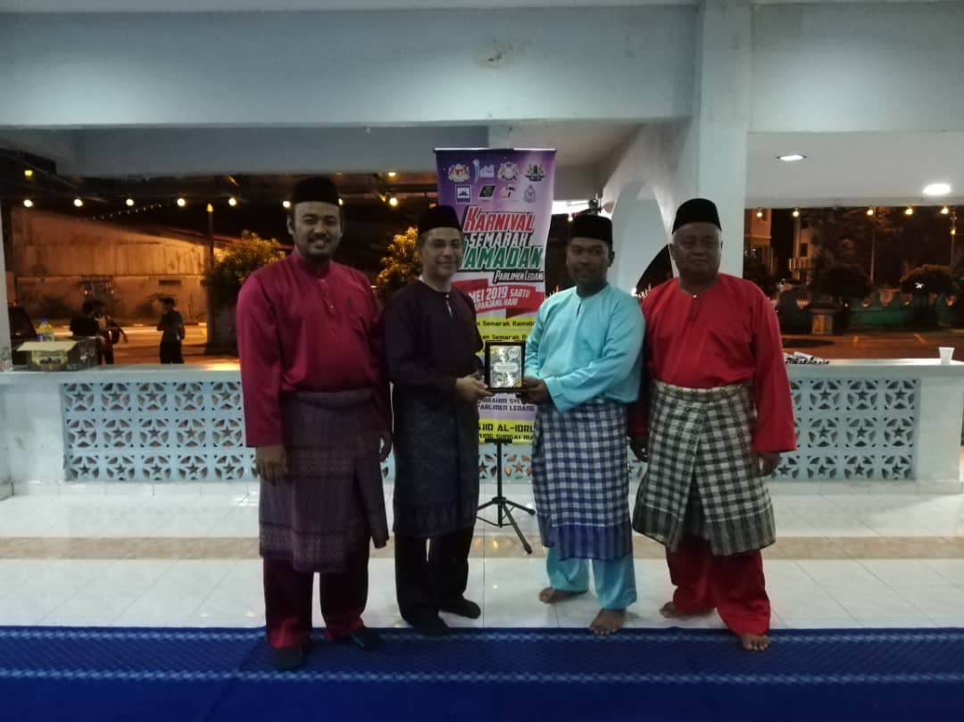 Penghulu Mukim Serom, Mahathir Ab Ghani (baju melayu biru) salah seorang penerima cenderamata daripada Syed Ibrahim selaku penyelaras bersama Program Karnival Semarak Ramadan Parlimen Ledang di DUN Serom.