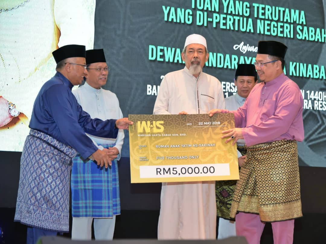 Hashim (kiri) mewakili Warisan Harta Sabah menyampaikan sumbangan kepada RAY As-sakinah Lok Kawi sambil diperhati Tun Juhar (tengah) dan Shafie (dua dari kiri).