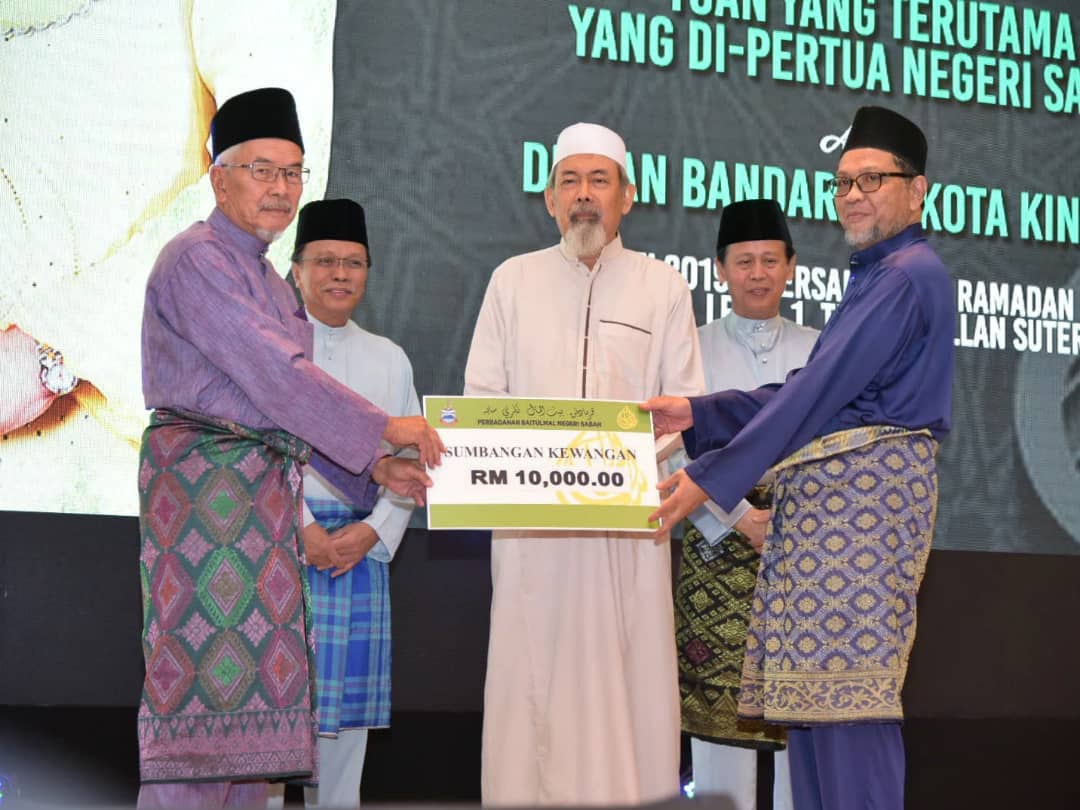 . Pengerusi Parbadanan Baitul Mal Negeri Sabah, Datuk Abdul Ghani Abdul Rashid (kiri) menyampaikan sumbangan RM10 ribu kepada wakil pusat tahfiz sambil diperhati Tun Juhar (tengah) dan Shafie (dua dari kiri).