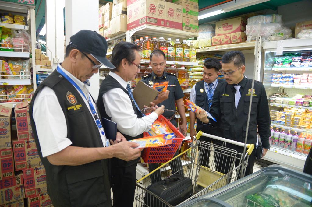 Ismuni (paling kanan) bersama pegawainya memeriksa makanan di sebuah pasaraya