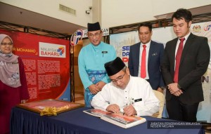 Ketua Menteri Melaka, Adly Zahari menurunkan tandatangan di buku pelawat di Pameran Jabatan Penerangan.