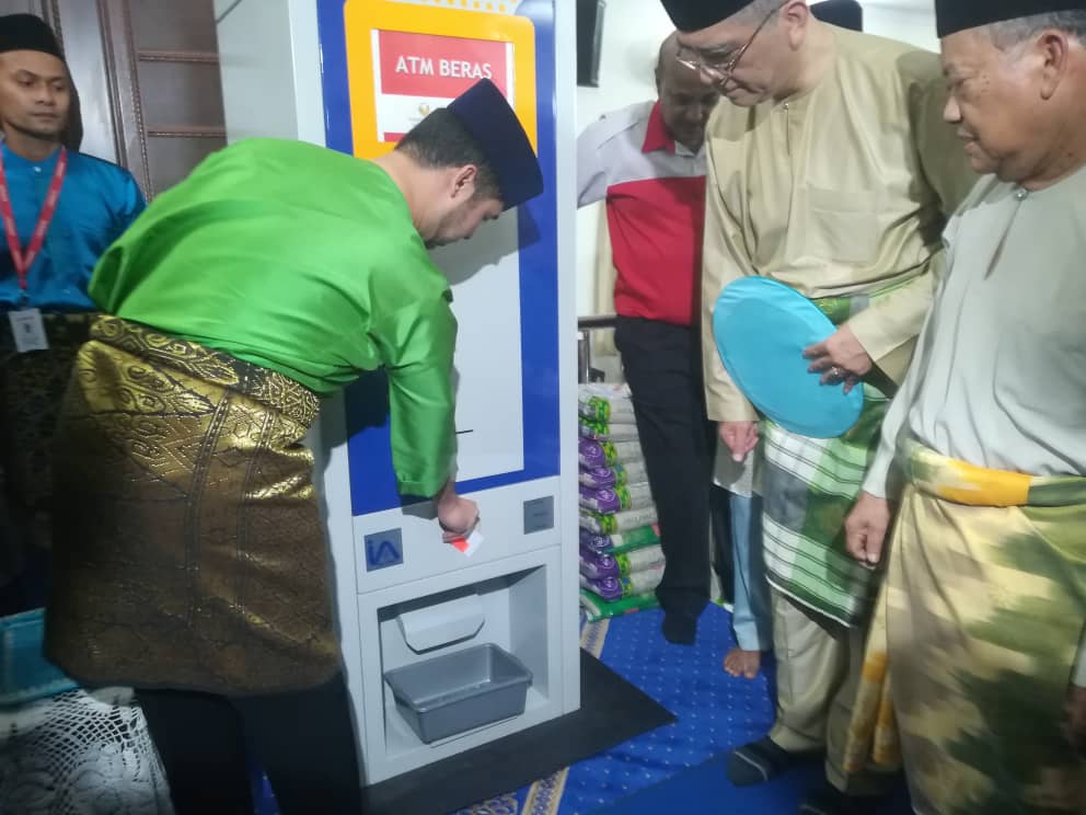 Tunku Idris menyaksikan demonstrasi pengeluaran beras dari mesin ATM beras