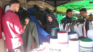 Nur Aszirah Asri sedang melayani pelanggan di kedainya yang menjual jubah dan kurta.