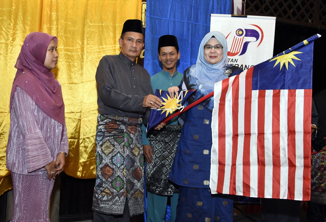 Azahar menyerahkan Jalur Gemilang kepada Pegawai Penerangan Daerah Kuala Terengganu, Rosnaini Arshad.