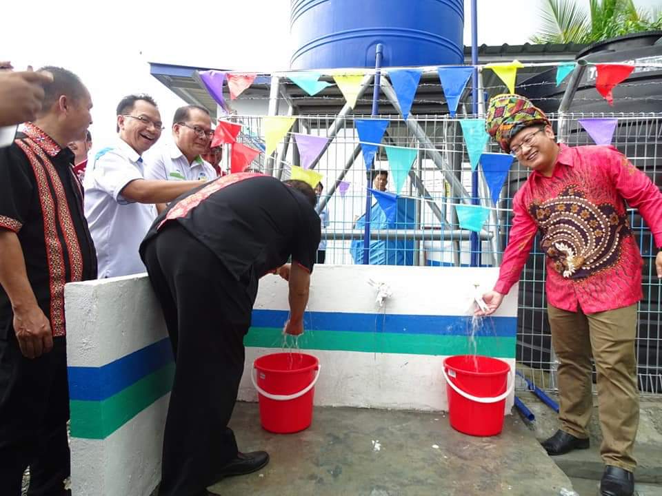 Ewon (kanan) dan Jimmy membuka paip sebagai simbolik perasmian Telaga dan Sistem Penapisan Air Kg.Piasau. 