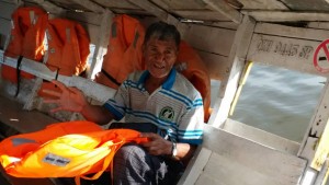 Bolhi menunjukkan jaket keselamatan yang terdapat di dalam perahu tambang miliknya.
