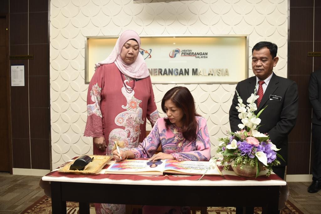 Suriani menurunkan tandatangan pada buka lawatan Jabatan disaksikan oleh Ketua Pengarah Penerangan, Roselindawati Abdul Rahman serta Timbalan Ketua Pengarah Penerangan (Kandungan Digital) Datuk Sukari Ab Hamid