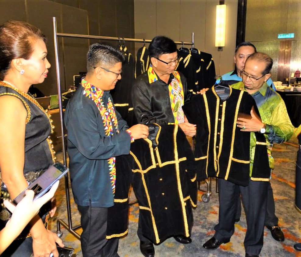 Ewon (tiga dari kiri) terpegun melihat kecantikan baju tradisi yang dijahit oleh peserta kursus jahitan anjuran KPLB Sabah. 