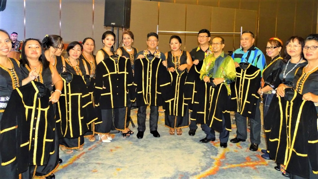 Ewon (tengah) dan Fredian mempamerkan baju tradisional bersama para peserta kursus jahitan anjuran KPLB Sabah. 