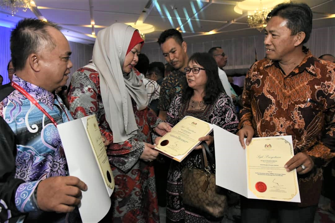 Rina (tengah) menyampaikan sijil penyertaan kepada peserta kursus. 