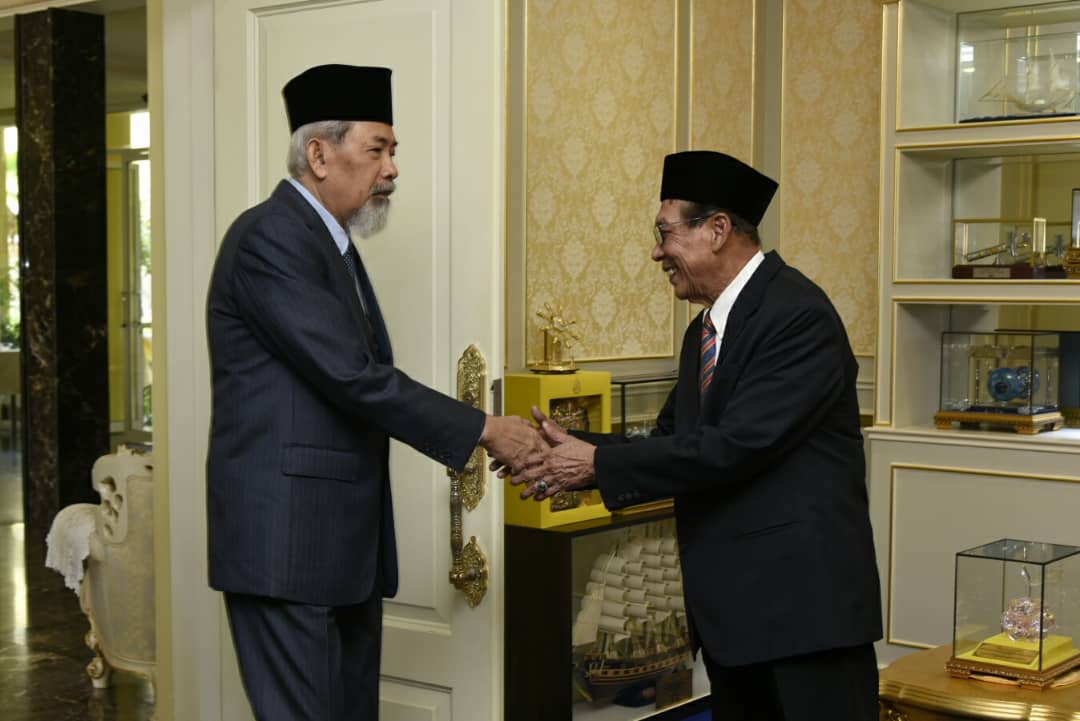 Tun Juhar (kiri) bersalaman dengan Abdul Rashid. 