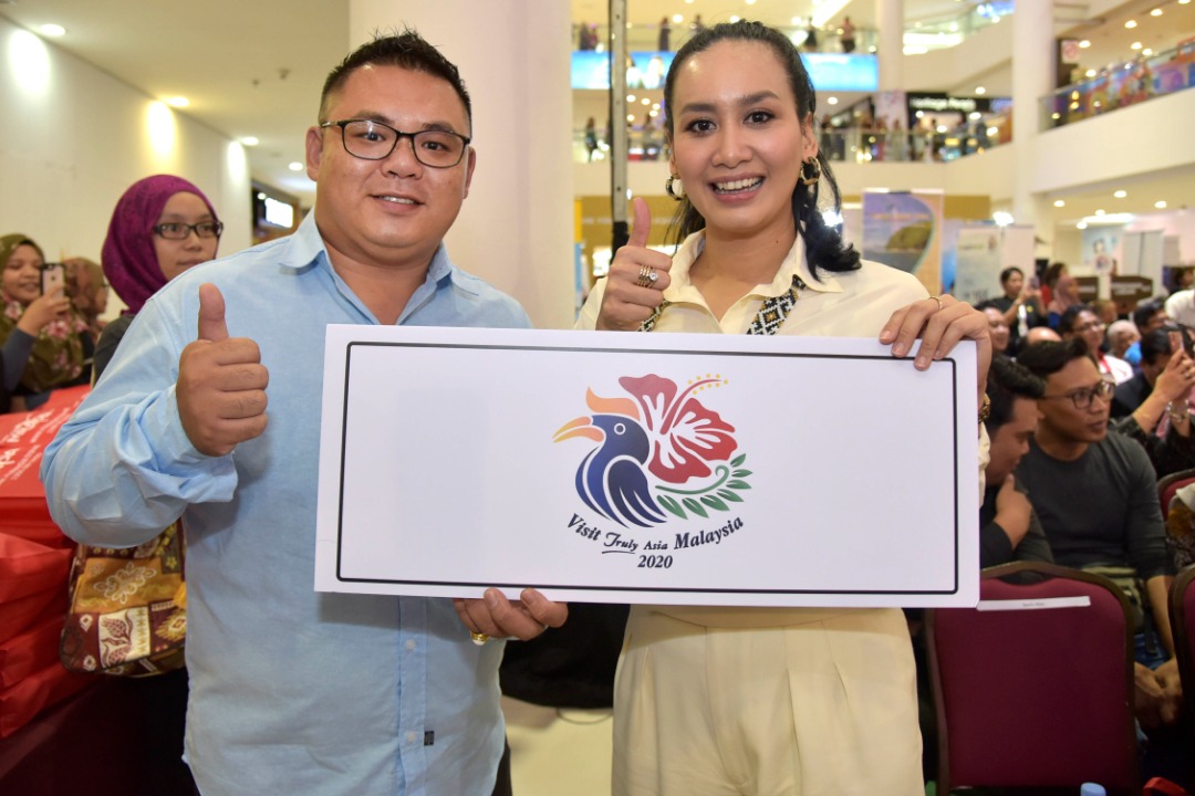 Marsha Milan Londoh (kanan) bersama salah seorang pengunjung turut mempromosikan Logo Visit Malaysia Truly Asia 2020. 