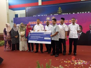 Menteri Besar Johor Datuk Dr. Sahruddin Jamal (lima dari kiri) menyampaikan cek Geran Pengoperasian Skim Rondaan Sukarela kepada para penerima. 