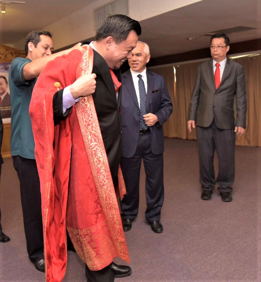Taufiq memakai jubah Naib Canselor UMS simbolik kepada pelantikannya sambil dibantu oleh D Kamarudin (kiri). 