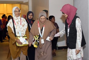 Petugas Operasi Haji (kanan) membantu jemaah haji sebelum menaiki bas ke Lapangan Terbang Sultan Mahmud, Kuala Nerus.