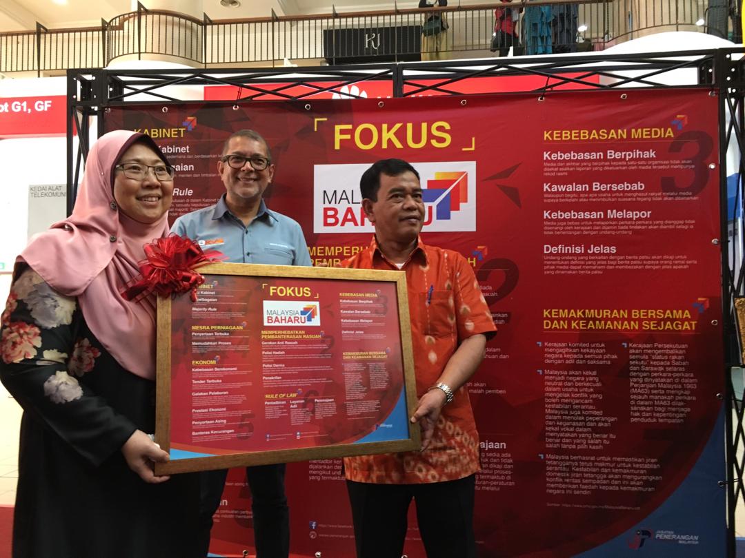 Fauziah (kiri) menerima cendera kenangan daripada Datuk Sukari Ab Hamid ketika melawat Pameran Malayisa Baharu