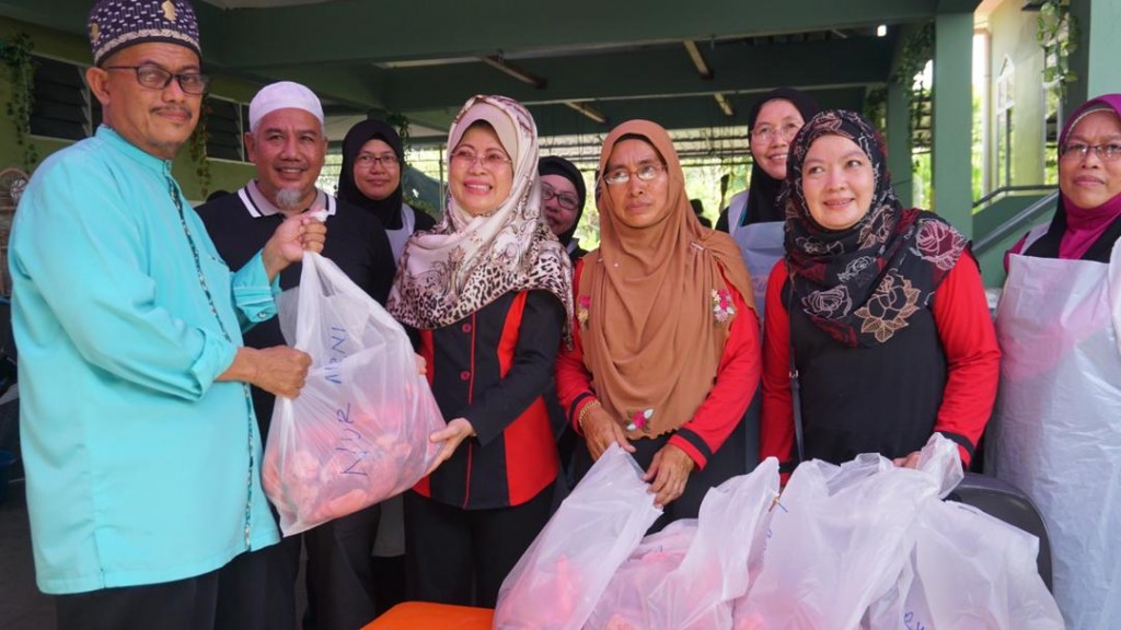 Dato Sri Hajah Fatimah Abdullah menyampaikan sumbangan kepada salah seorang penerima