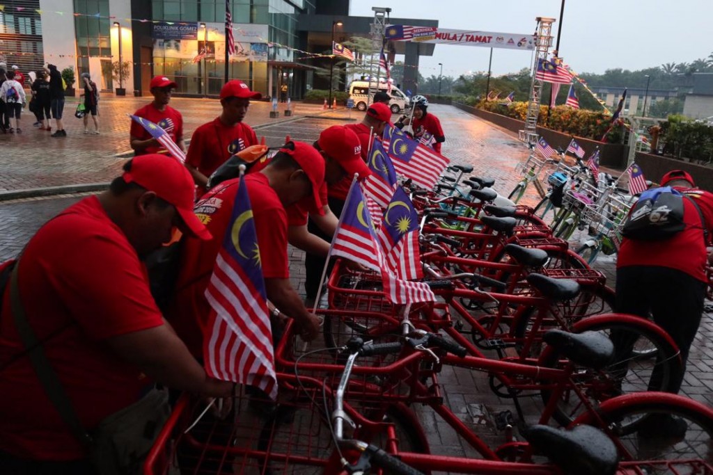 Wakil dari Pos Malaysia menghias basikal mereka dengan Jalur Gemilang