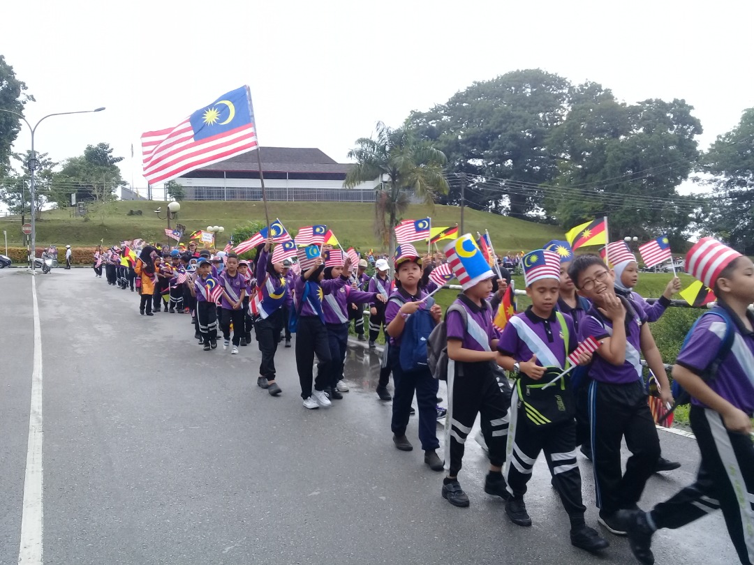 Perarakan  pelajar sekolah sambil  membawa bendera tangan dan Jalur Gemilang mengelilingi bandar Sri Aman