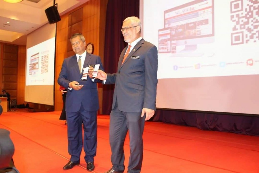 Khalid (kanan) bersama-sama Ketua Setiausaha Kementerian Wilayah Persekutuan, Datuk Seri Saripuddin Kasim (kiri) membuka portal Wilayahku menggunakan telefon pintar.