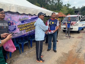 Wakil Pegawai Penerangan Daerah Dungun, Mazlan Tawang menyampaikan gimik penyerahan Jalur Gemilang kepada Ketua Polis Daerah Dungun Superintendan Baharudin Abdullah (Bertopi)