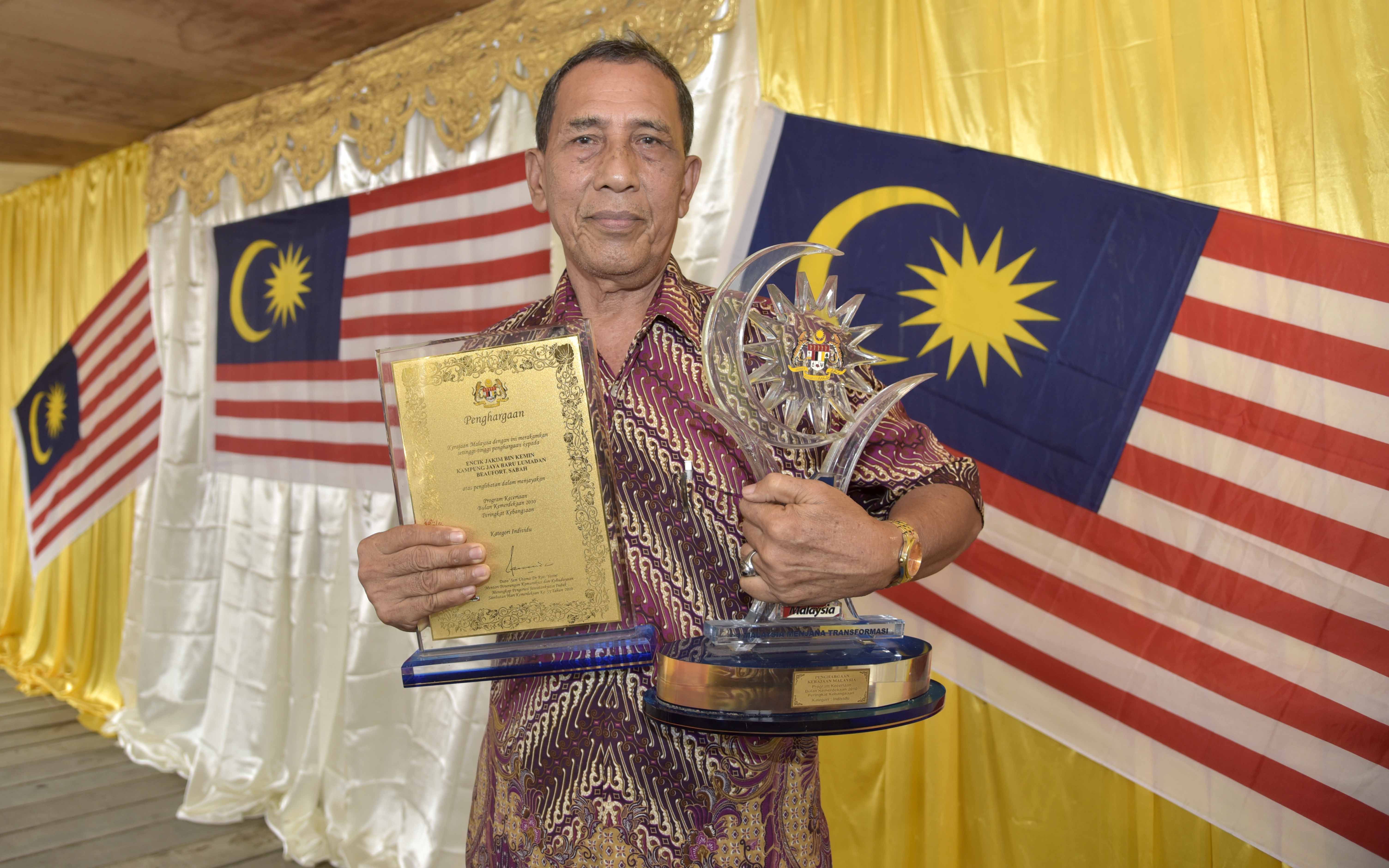 Jamal Kemin, bersama sijil dan trofi yang diterima pada tahin 2010 di Putrajaya. 