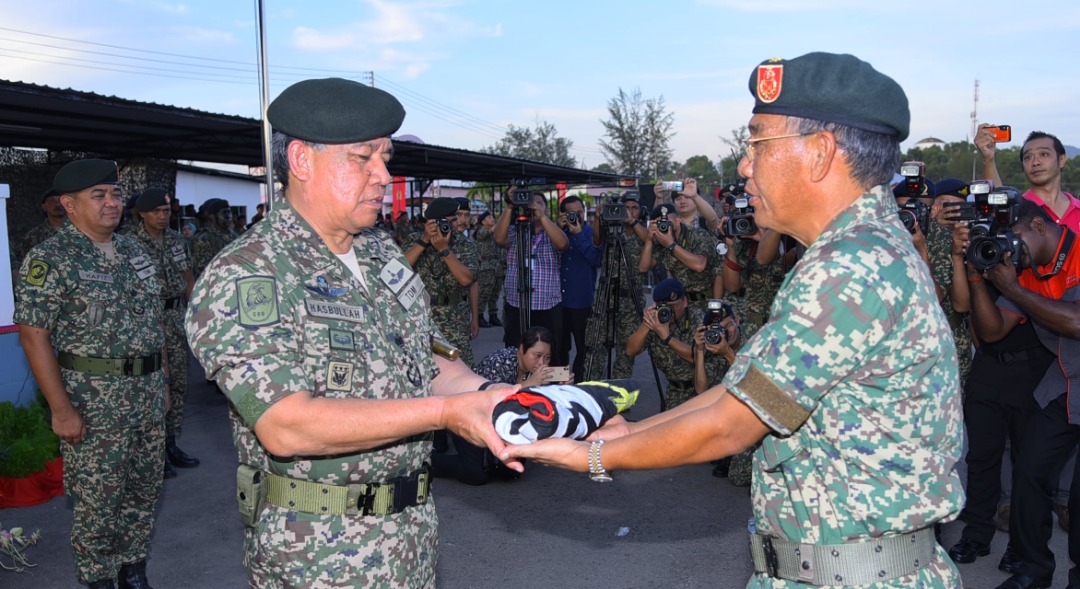Panglima 5 Div, Mejar Jeneral Datuk Mohamad Khir Abdullah (kanan) menyerahkan bendera AT 450 yang diturunkan kepada Panglima Tentera Darat (kiri).