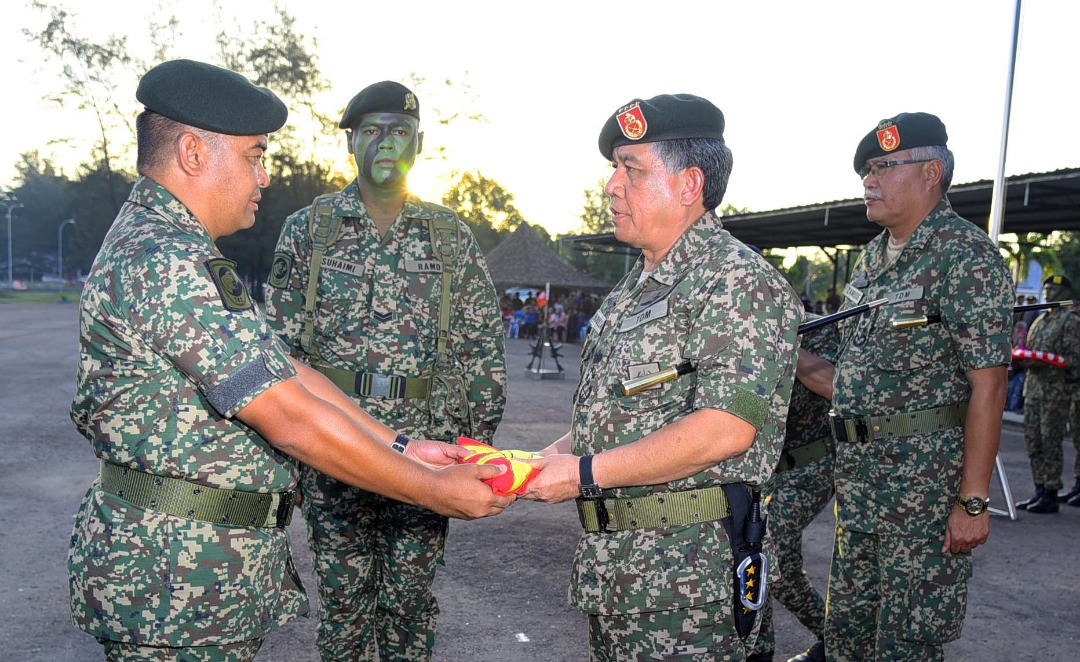 Panglima 5 Bgd, Brigadier Jeneral Muhammad Hafizuddein Jantan (kiri) menyerahkan bendera 5 Bgd kepada Panglima Tentera Darat (kanan) sebelum dibawa keluar dari Kem Lok Kawi untuk dikibarkan di Kem Paradise Kota Belud.