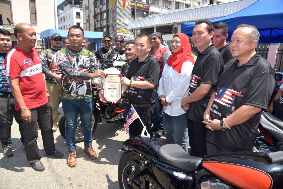 Chan Foong Hin menyampaikan sijil kepada penunggang motorsikal yang turut serta pada karnival tersebut 