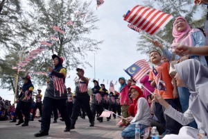 Orang ramai mengibarkan Jalur Gemilang sambil menyaksikan perarakan sempena sambutan Bulan Kebangsaan 2019 peringkat negeri Terengganu di Dataran Batu Burok, Kuala Terengganu