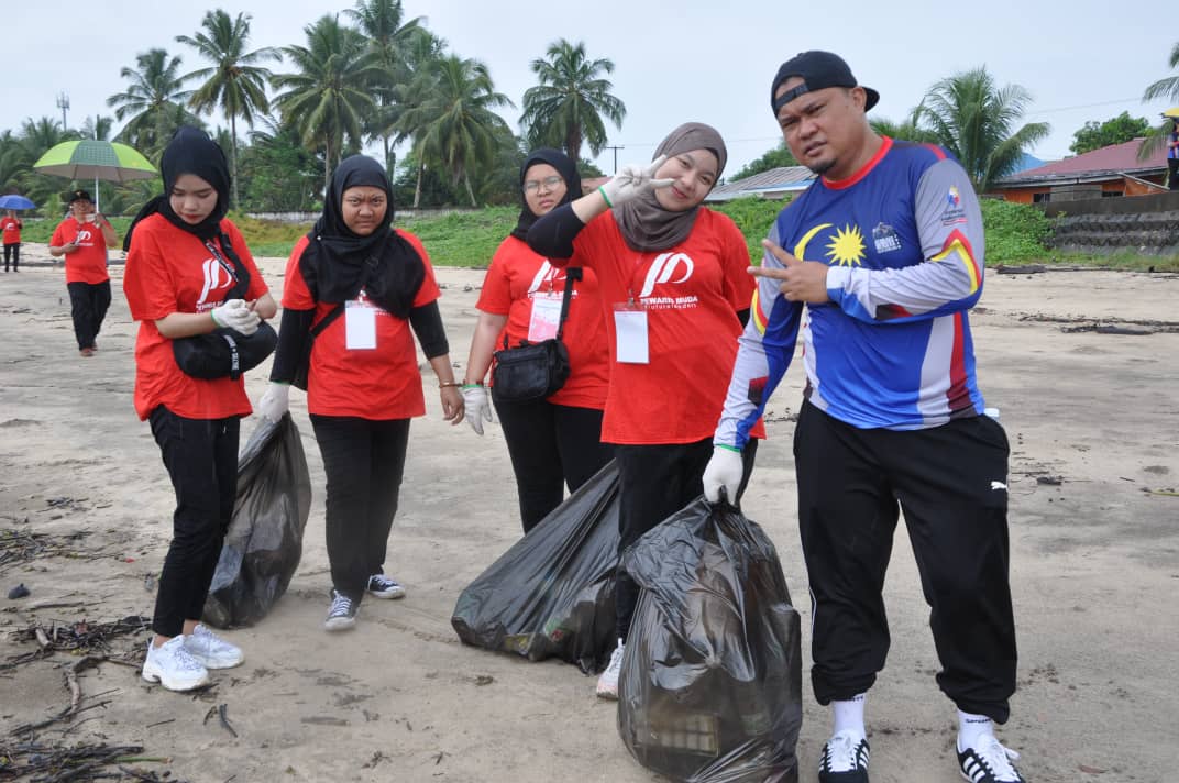 Para peserta bersama dengan anggota JaPen menjalankan gotong-royong membersih  pantai Santubong