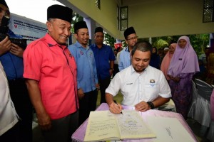 Datuk Dr Sahruddin Jamal menandatangani buku pelawat semasa merasmikan Sekolah Agama Kerajaan Johor, Melayu Raya.