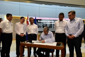 Tun Mahathir (dua dari kanan) menurunkan tandatangan pada buku pelawat semasa melawat Kompleks Kastam, Imigresen dan Kuarantin Bangunan Sultan Iskandar. 
