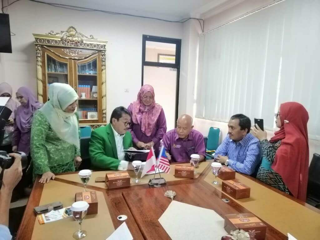 Proses menandatangani sijil kerjasama antara PMM dan UMJ.