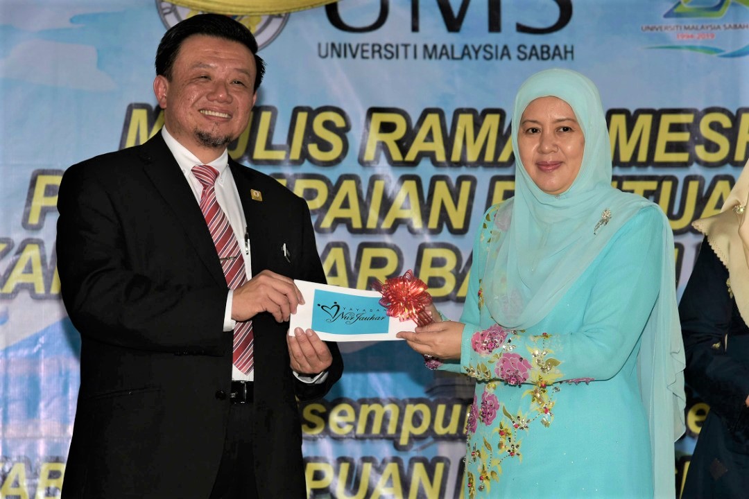 Toh Puan (kanan) menyampaikan sumbangan Yayasan Nur Juhar kepada Taufiq (kiri).