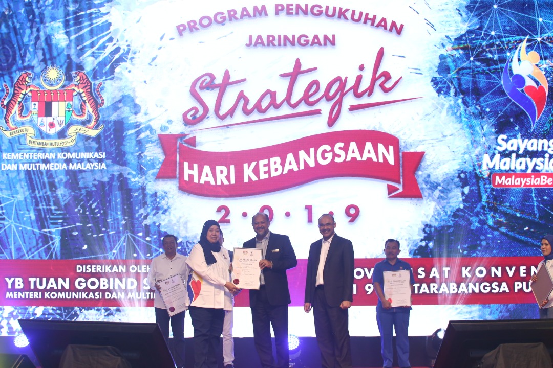 Ketua Pengarah Jabatan Penerangan Malaysia Puan Roselindawati Abdul Rahman menerima penghargaan daripada YB Menteri Komunikasi dan Multimedia Malaysia Tuan Gobind Singh Deo dalam menjayakan Sambutan Hari Kebangsaan dan Hari Malaysia 2019