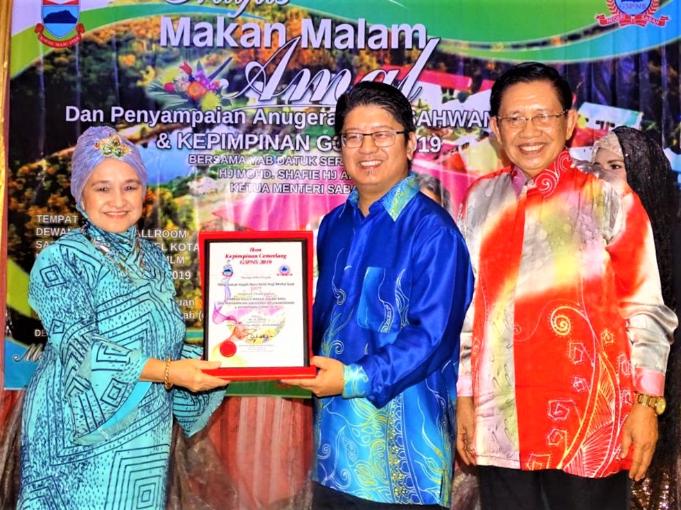 Ewon (tengah) menyampaikan Anugerah Ikon Kepimpinan Cemerlang G3PNS 2019 kepada Datuk Noni Said, turut kelihatan Pengerusi Penganjur merangkap Presiden G3PNS Datuk Haji Noortaip Haji Suhaili.