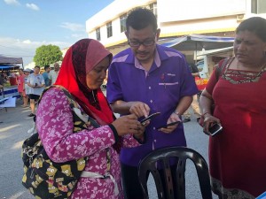 Orang ramai mendapatkan bantuan pendaftaran e-tunai