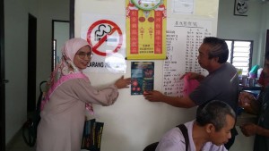 Pegawai Penerangan Daerah Dungun, Rusmiza Anuar menampal risalah pencegahan koronavirus di restoran Batu 5, Dungun.