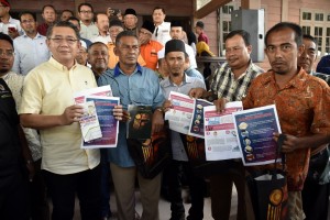 Salahuddin bersama petugas Pejabat Penerangan Daerah Setiu mengedar risalah cegah wabak Koronavirus pada majlis penyampaian bantuan bencana kepada ahli Pertubuhan Peladang di Peladang Setiu Agro Resort, Setiu