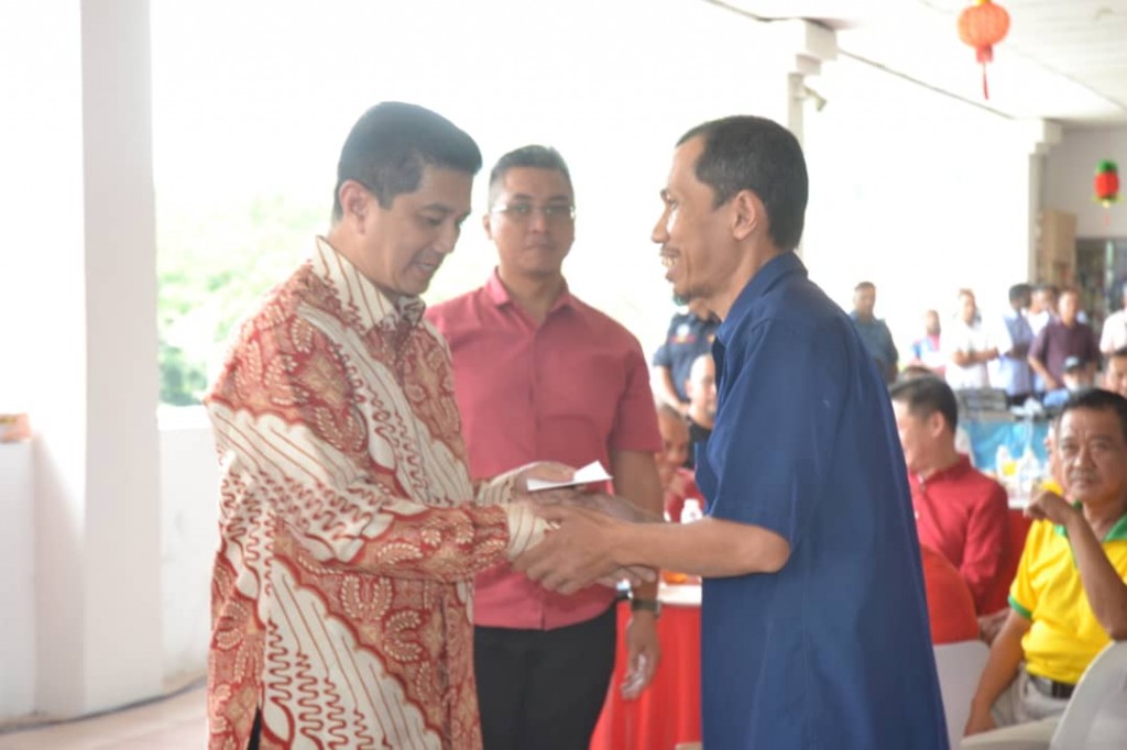 Azmin (kiri) menyampaikan sumbangan kemasyarakatan sempena sambutan Tahun Baharu Cina di Pasar Moden Taman Sri Gombak, hari ini.