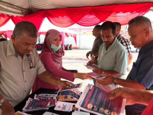 Petugas Jabatan Penerangan Daerah Kuala Terengganu mengedarkan risalah mengenai langkah pencegaham coronavirus, e-tunai dan penurunan kadar tol 18%