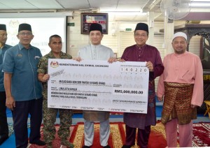 Mohamed Azmin menyerahkan replika cek kepada Menteri Besar Terengganu, Ahmad Samsuri Mokhtar